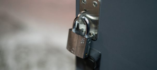 Padlock,On,Gate,Of,Small,Gray,Container,Closeup,.,High