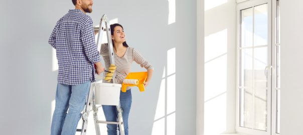 Young,Family,Couple,Doing,Renovations,And,Painting,Walls,Inside,House.