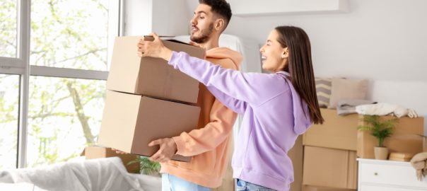 Young,Couple,With,Cardboard,Boxes,In,Room,On,Moving,Day
