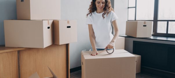 Young,Hispanic,Woman,Is,Packing,Containers,With,Sticky,Tape.,Happy